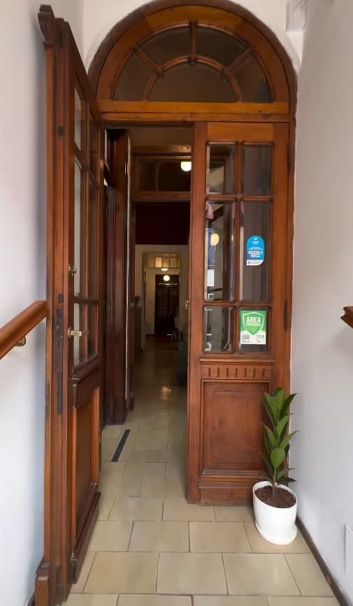 Puerta de entrada de madera con arco de Humanus en De La Nación 394