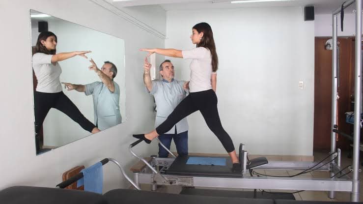 Profesional de Humanus acompañando un ejercicio en el reformer de Pilates